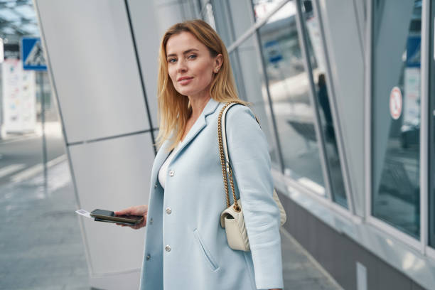 istock Tranquil stylish woman with travel document posing for camera 1352121840