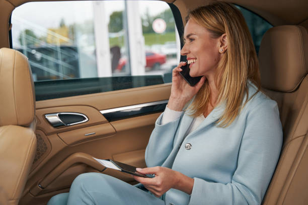istock Cheerful taxi passenger talking on her smartphone 1352121852