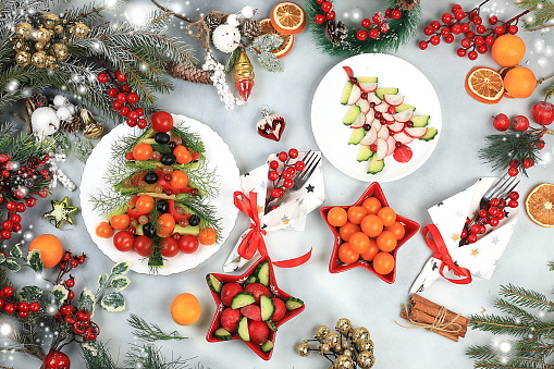 Christmas New Year dishes, traditional festive salad with edible vegetarian Christmas trees made of vegetables and fruits, food design idea, fir branches and decorations ,, flat lay, selective focus