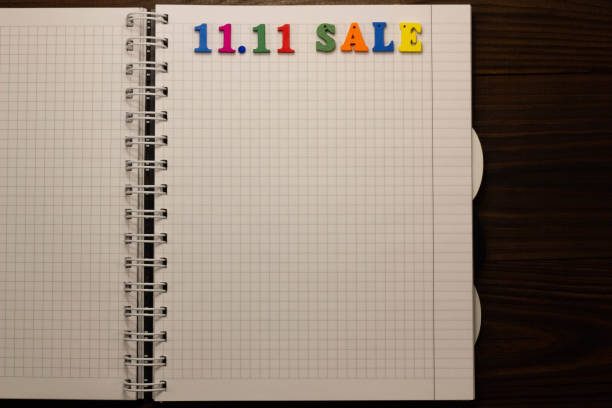 istock 11.11 Sale concept. Multicolored colorful letters in a squared exercise book on the table with copy space for text. Shopping list. Mega Shopping Day. Ready to shopping. Biggest sale. Close-Up 1352122738