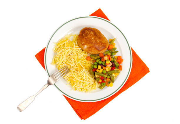 Plate with noodles, vegetables and breaded cutlet. Studio Photo