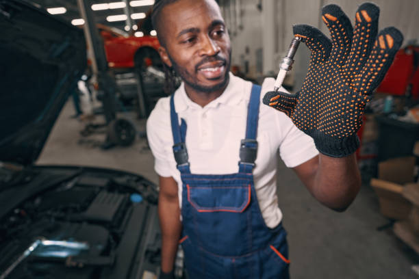 istock Afro-American man holding spark plug in car workshop 1352125049