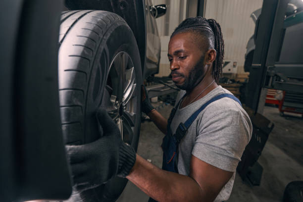 istock Serious auto mechanic taking off car wheel 1352125059