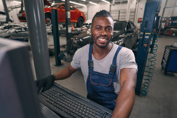 istock Multiracial auto mechanic smiling to camera from computer terminal 1352125080