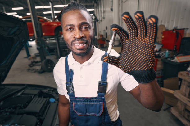 istock Smiling mixed-race male showing spark plug to camera 1352125113