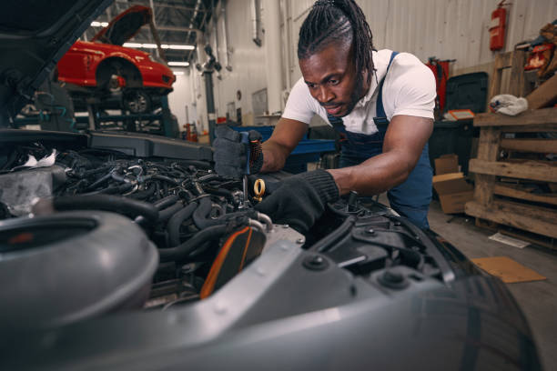 istock Multiethnic repairman using screwdriver on engine parts 1352125144