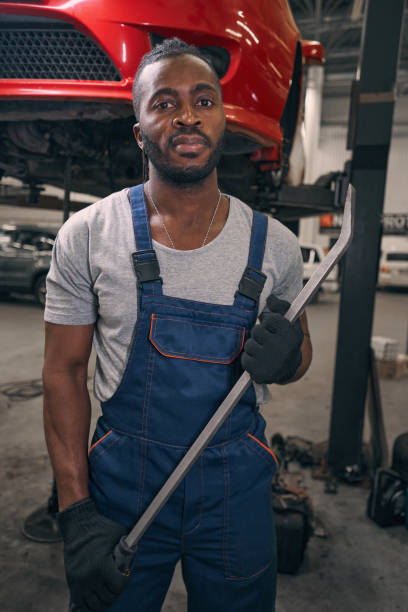 istock Car repair worker posing for camera with crowbar 1352125155