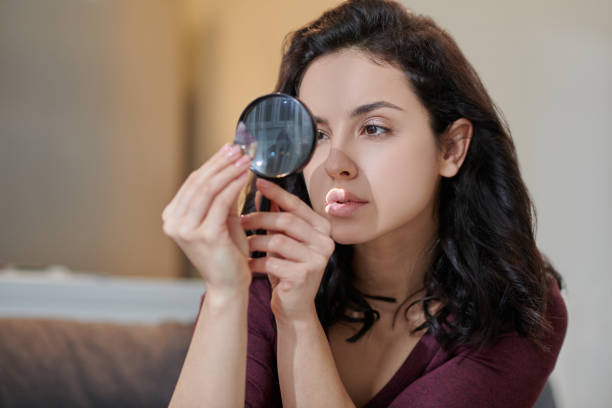 istock Dark-haired female focused on examining an amethyst 1352128882