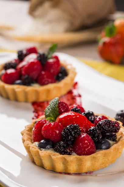 istock Two Fruit Pies with raspberries, blueberries and mulberries in a plate over the table. 1352131209