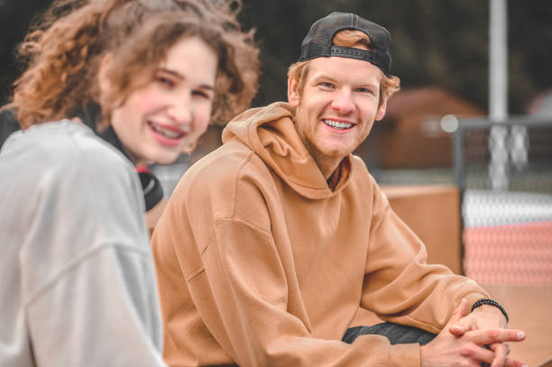 istock Smiling guy and girl looking at camera outdoors 1352138076