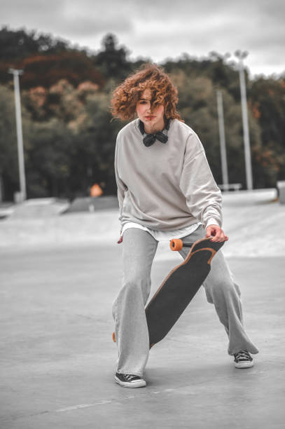 istock Girl on bent legs touching skateboard with her hand 1352138127