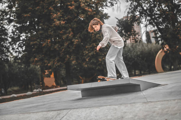 istock Girl on skateboard driving onto springboard 1352138140