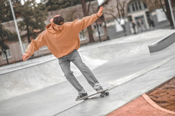 istock Guy with hands to sides riding skateboard in skatepark 1352138165