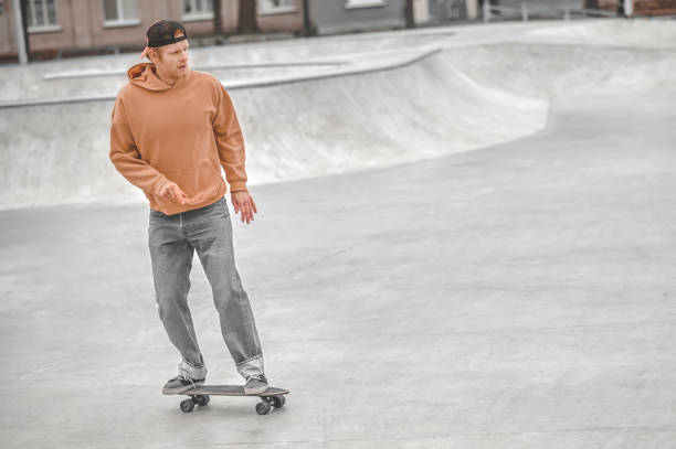 istock Guy in cap riding skateboard in park 1352138166