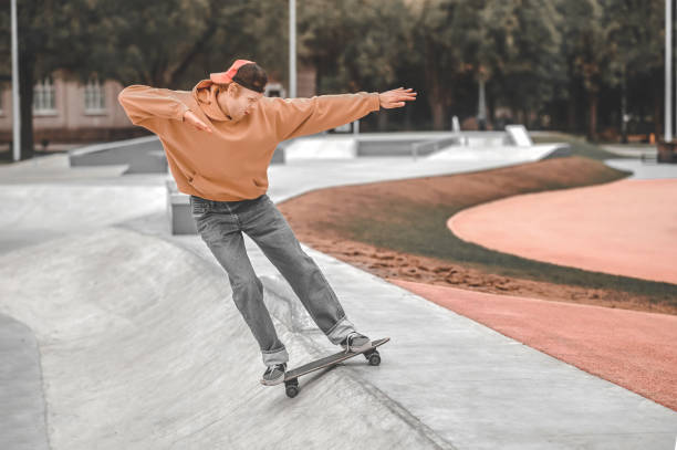 istock Cheerful guy on skateboard sliding down 1352138169