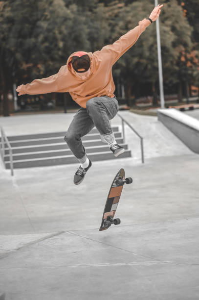 istock Guy bouncing high in air and skateboard falling below 1352138171