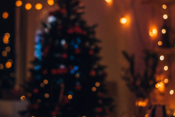 Blurred lights of a garland on a Christmas tree on a dark background.Festive Christmas and New Year background. stock photo