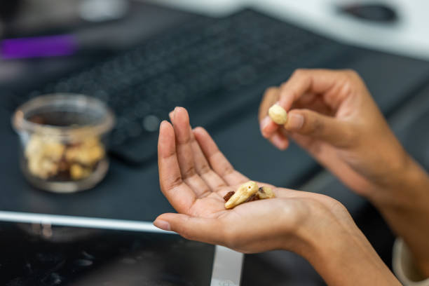 Close-up of female hands holding nuts at an office desk