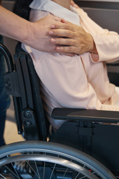 istock Man supporting woman with disability at home 1352139663