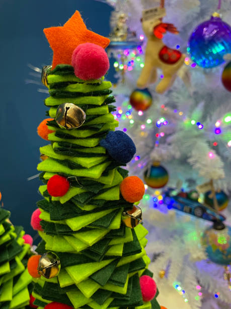 istock Image of model Christmas tree made from light and dark green felt squares spiralling round a wooden pole, focus on foreground 1352140620