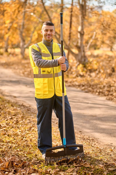 istock A man in a yellow vest with rake in the park 1352142873
