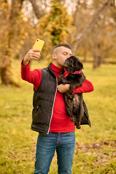 istock A man with his dog in hands making selfie 1352142940