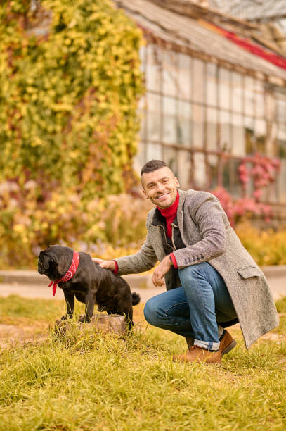 istock A man with a black dog in the autumn park 1352142973