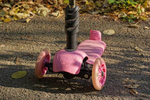 istock one pink black scooter stands on gray asphalt 1352145781