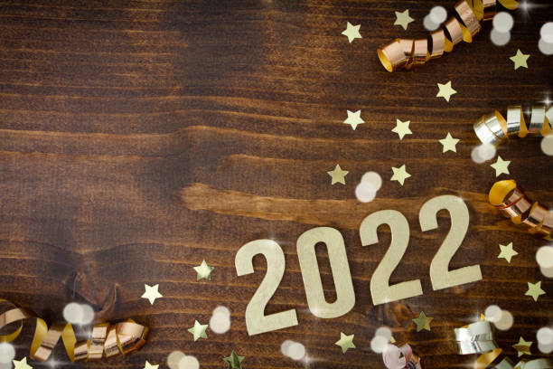 New Year 2022 2022 written in gold on a wooden background with gold stars. ribbons and lights.
With copy space. 2022 photos stock pictures, royalty-free photos & images