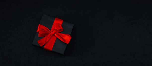 istock A black small gift box with a red ribbon tied in a bow 1352149509