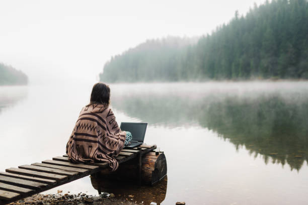 istock Woman Relaxing In Nature And Using Technology 1352151269