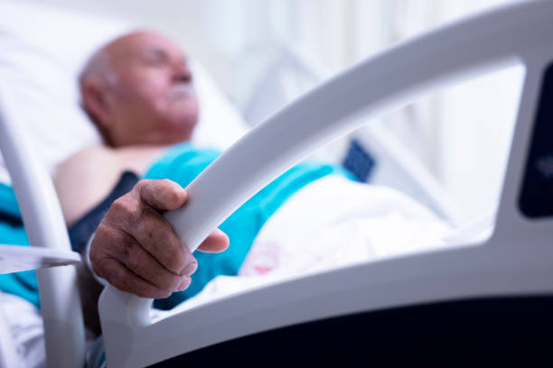 istock Sick and Senior Man Wearing Hospitable Gown Lying in Bed 1352151270