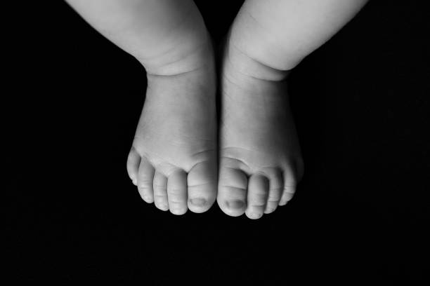 istock Newborn baby feet on black background 1352151918