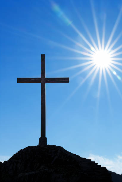 istock Christian cross over beautiful sunset background vertical image 1352154551
