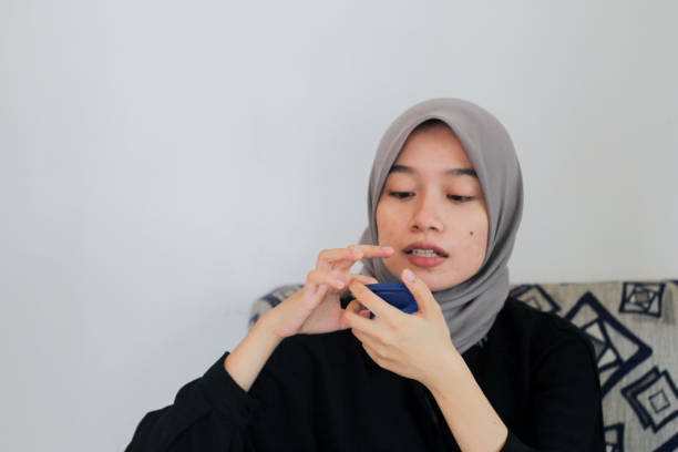 istock young women using lip care at home 1352156637