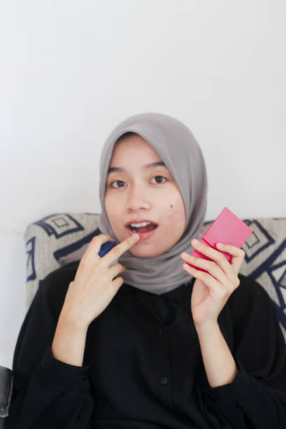istock young women using lip care at home 1352157031