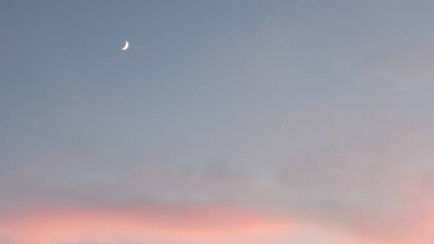 istock Moon and Venus over pink cloud 1352159814
