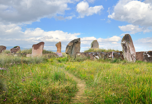 The burial mound of the 5th century BC, steles of red stone under a blue sky. Siberia, Russia
