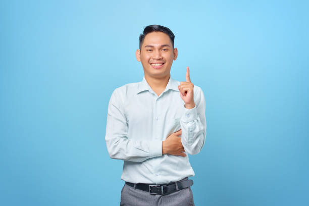 istock Happy young handsome businessman having a creative idea and looking camera on blue background 1352164508