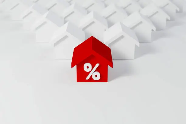 Photo of Miniature red roof house with percent icon among white houses for real estate property industry. 3d illustration
