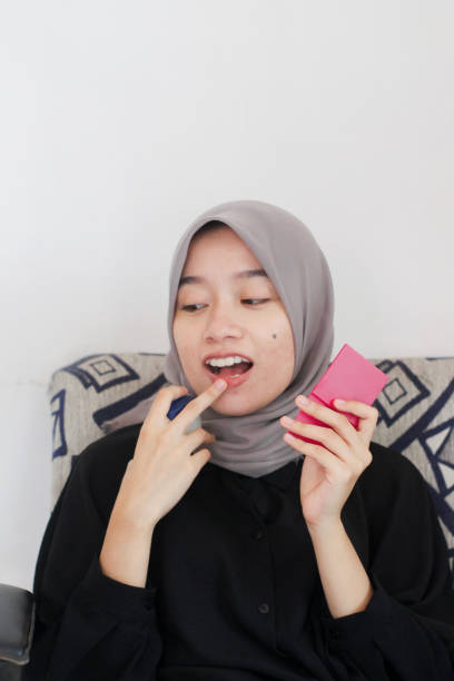 istock young women using lip care at home 1352165501