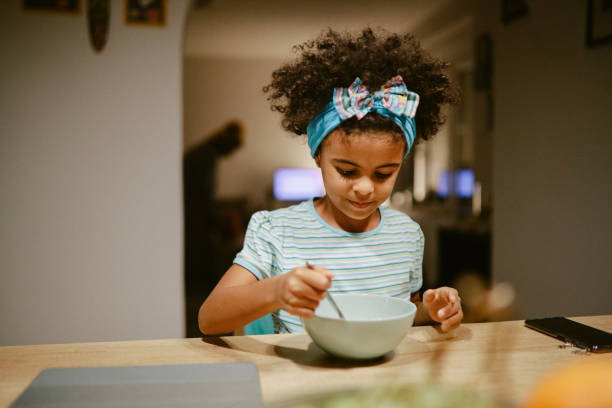 istock Young girl eating dinner before bed 1352165591