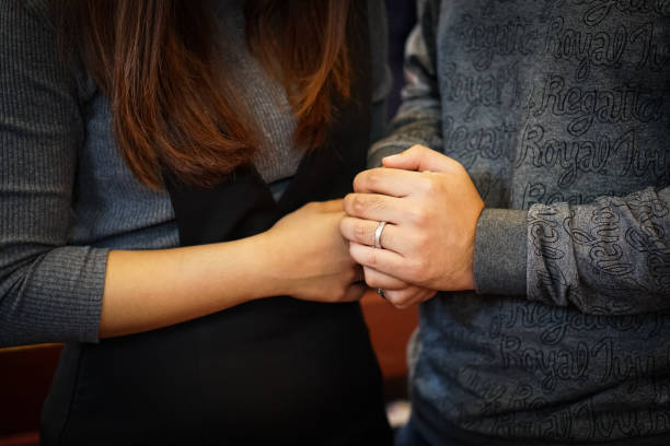 A couple holding hands praying. stock photo