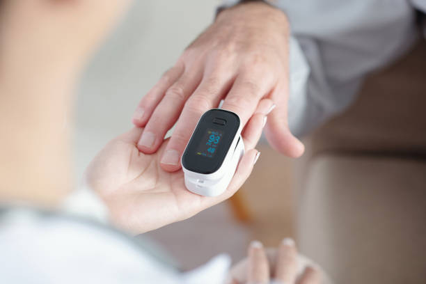 Doctor Helping Patient to Put On Pulse Oximeter stock photo