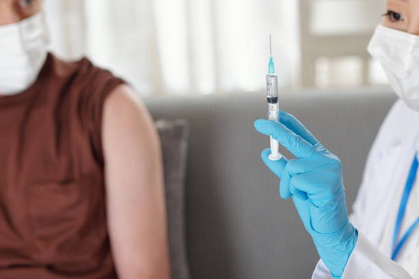 istock Doctor Showing Syringe with Vaccine 1352168990