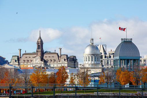 View of Montreal City Hall and Bonsecour Market from Île Sainte-Hélène. The photo was taken with a tele-lens. The Canadian flag can be seen flying in the wind.