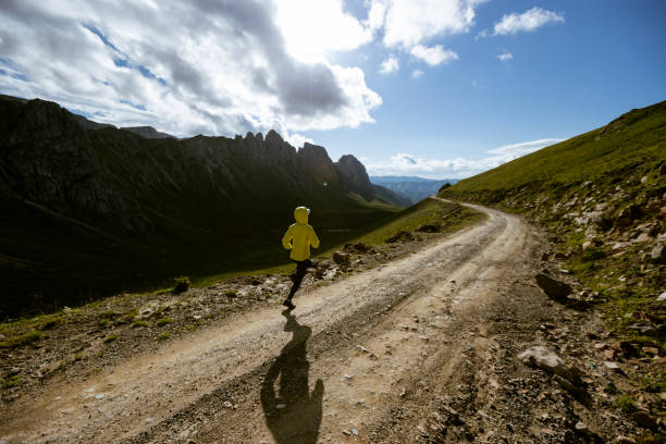 Woman trail runner running on mountain top
