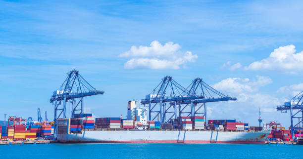 istock Cargo ship and truck at seaport waiting for container dock crane  shipment harbour loading container boxes import and export commercial trade business logistic and transportation of international. 1352181678