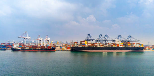 istock Cargo ship and truck at seaport waiting for container dock crane  shipment harbour loading container boxes import and export commercial trade business logistic and transportation of international. 1352181775