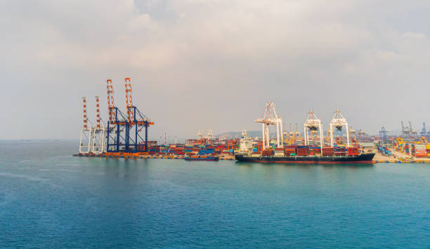 istock Cargo ship and truck at seaport waiting for container dock crane  shipment harbour loading container boxes import and export commercial trade business logistic and transportation of international. 1352181776